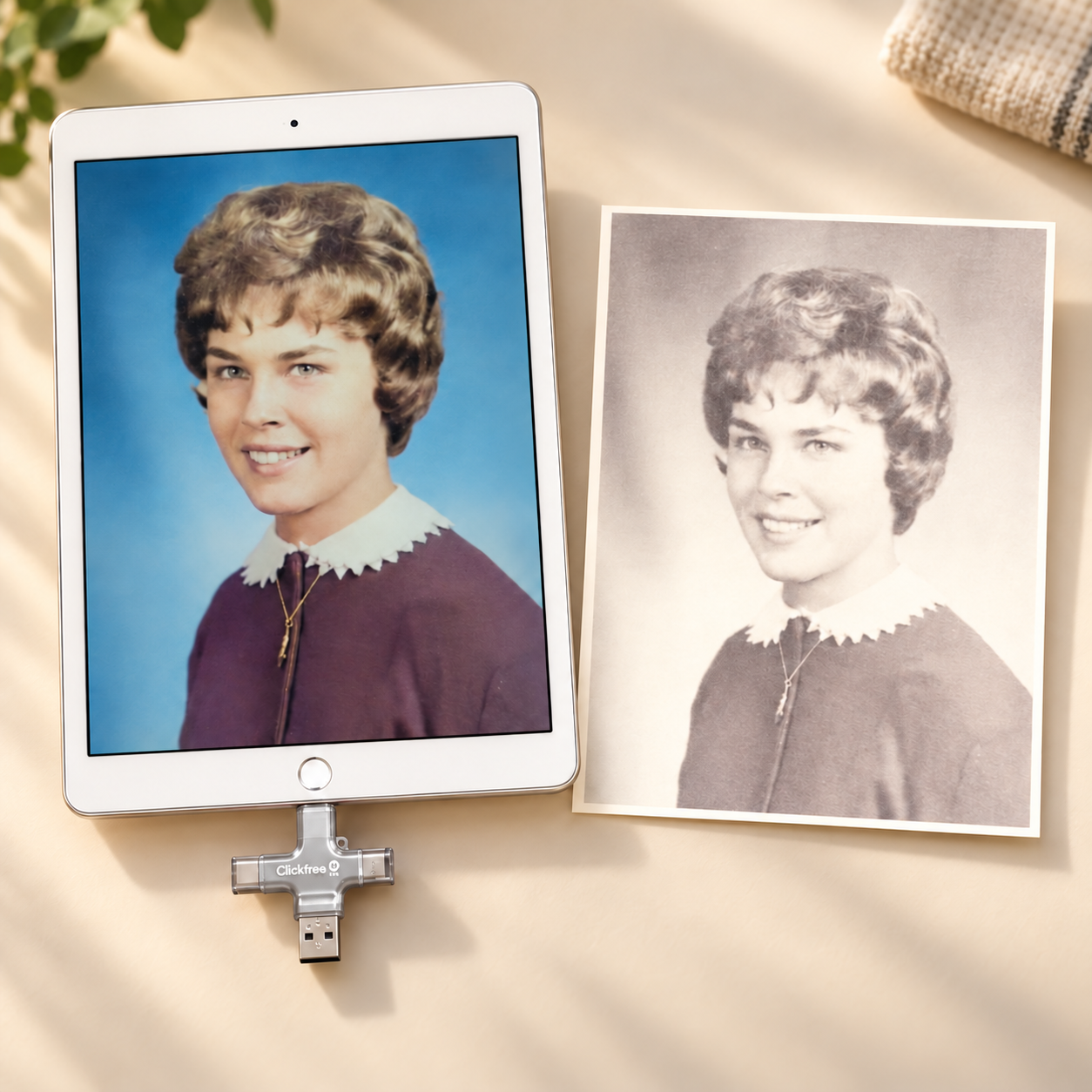 Illustrative photo-revival scene with a silver Clickfree device connected to a tablet beside a vintage printed portrait